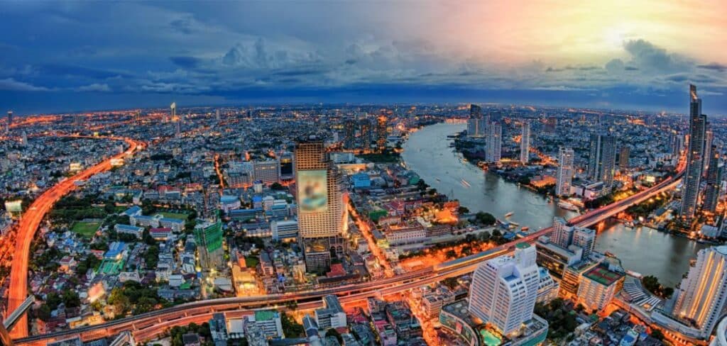 Aerial Night View Of Bangkok Skyline With The Chao Phraya River And City Lights
